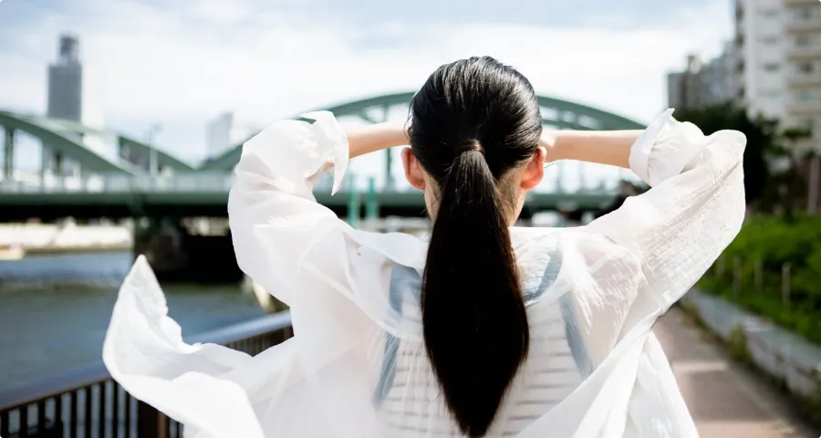 川と橋を眺める女性の後ろ姿