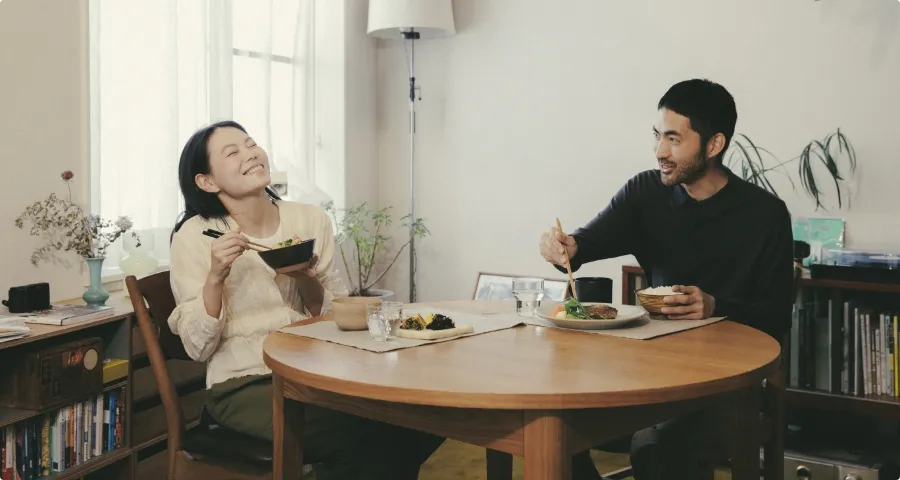 食卓を囲み笑顔で食事をする男女
